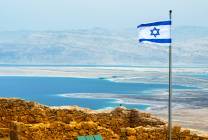 israeli-flag-with-the-ruins-on-masada-with-the-dead-sea-on-the-background-889843646_5113x3409