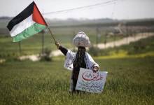 a_palestinian_woman_waves_her_national_flag_during_an_event_marking_land_day_near_the_israel-gaza_border_afp_march_30_2020
