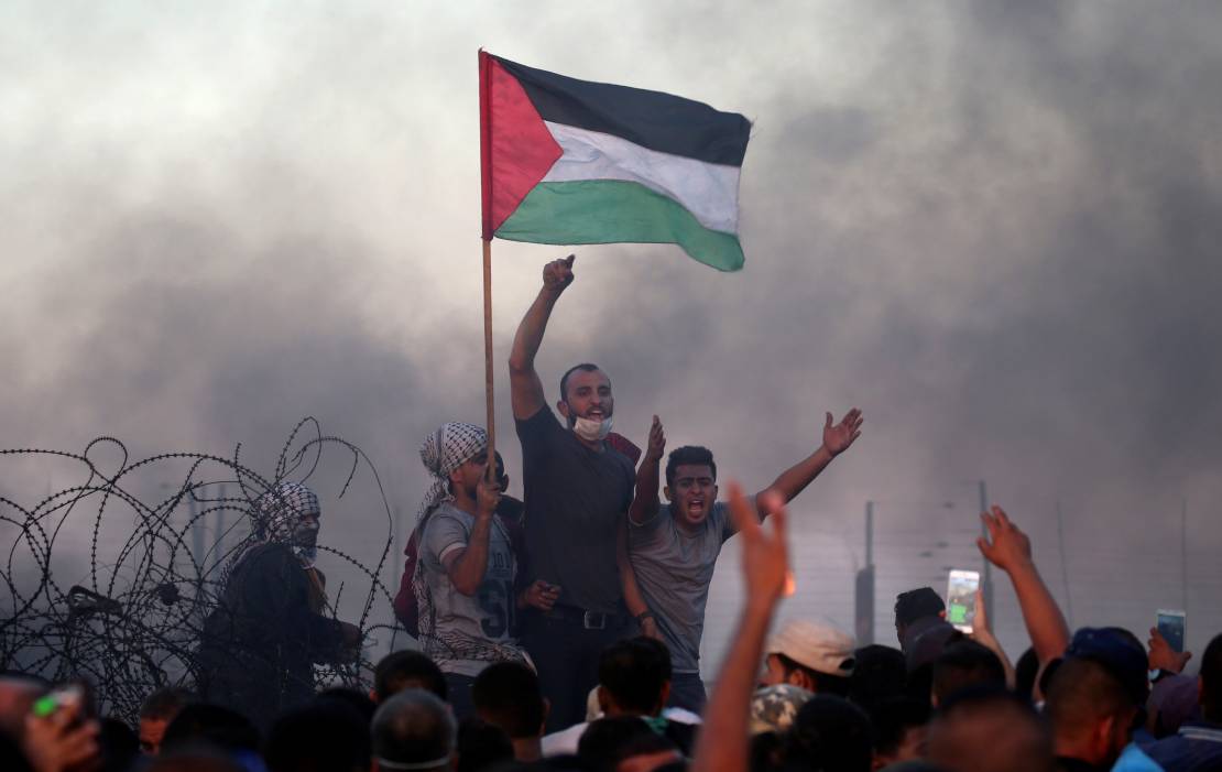800424-الفلسطينيون-يرفعون-شعارات-خلال-احتجاجاتهم-على-السياج-الحدودى